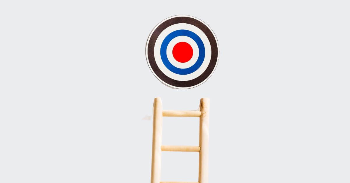 A wooden ladder leading up to a target board