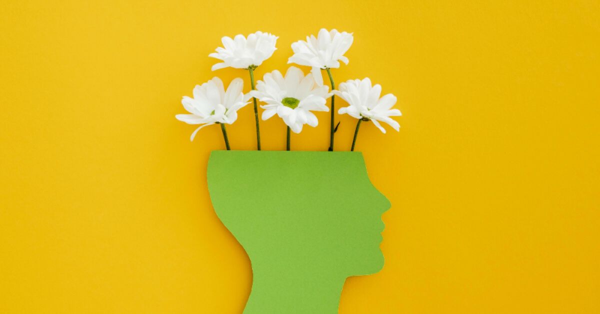 Paper cut out of a green head with white flowers