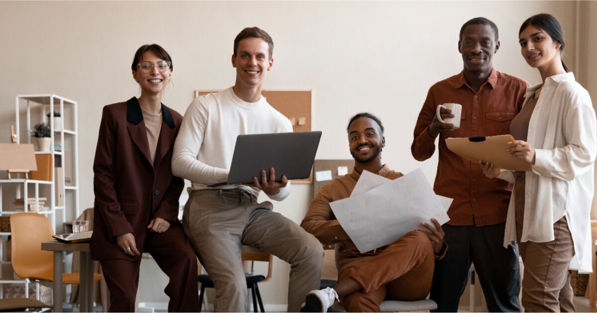 A diverse group of employees posing midst discussion