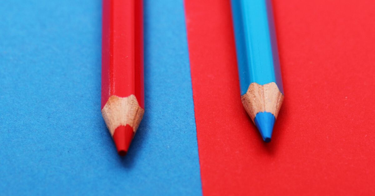 Blue and red color pencils against red and blue backdrops