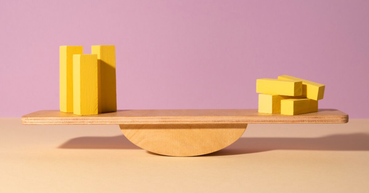 A seesaw balancing yellow blocks on both sides.