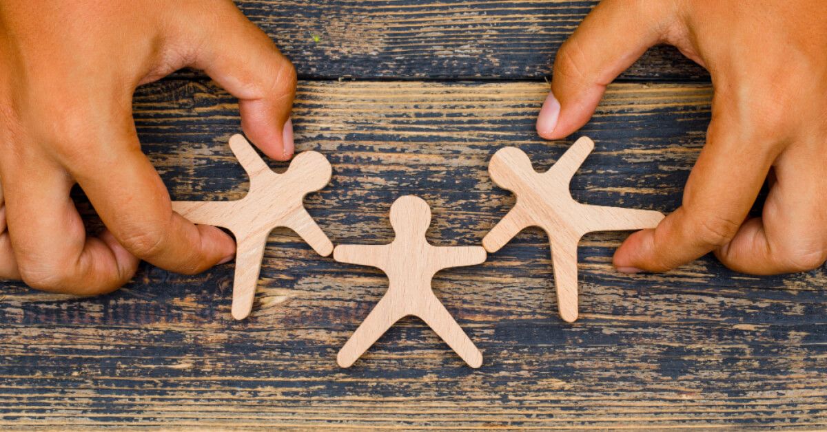 Three wooden human figurines arranged next to each other