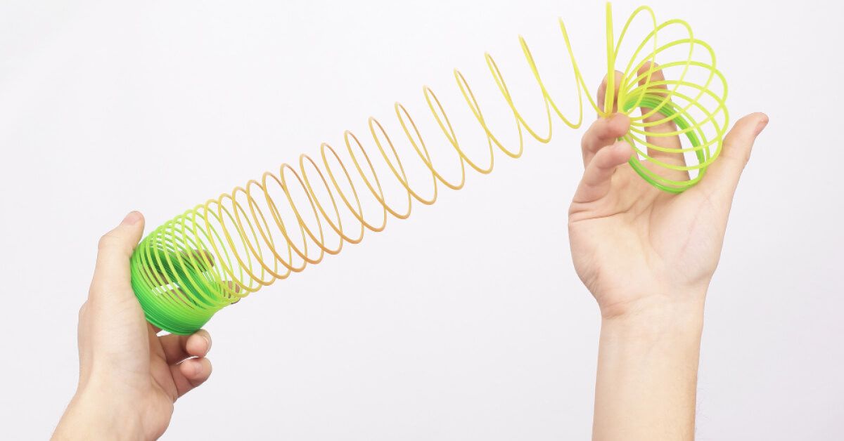 Person handling a green slinky toy