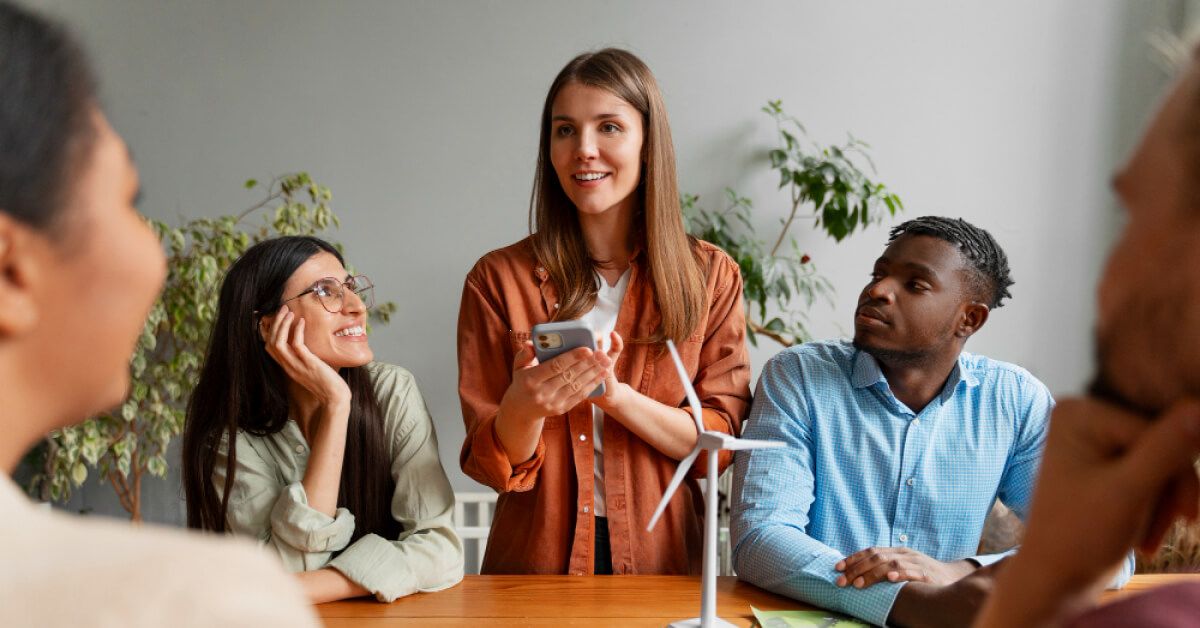 Person holding a phone, talking in discussion with peers