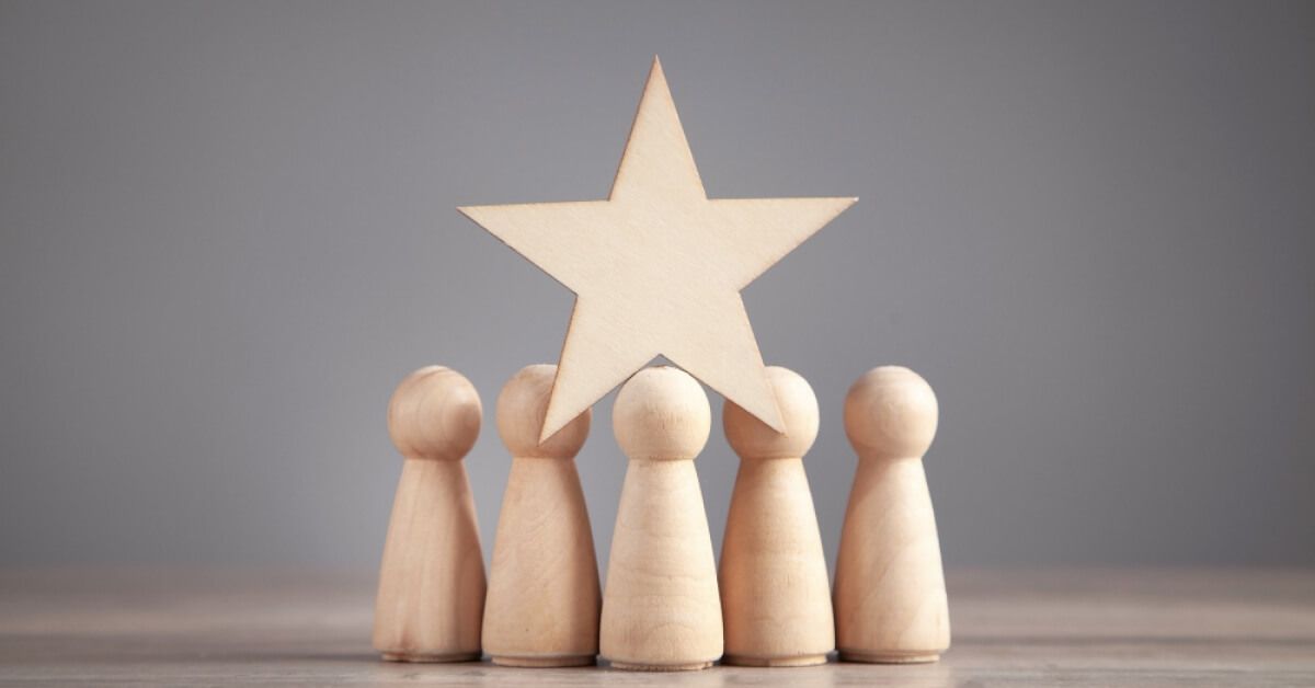 A group of wooden pawns with a wooden star on top