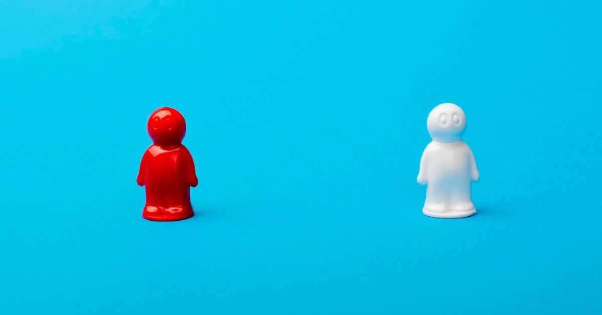 Red and white humanoid figure toys standing against a blue backdrop