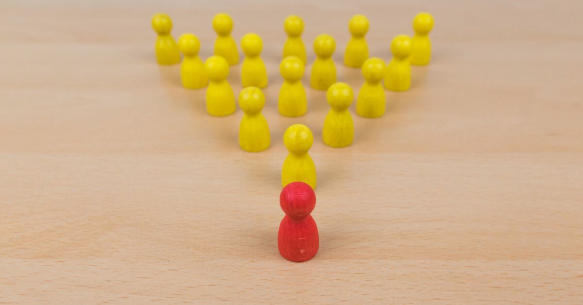 A red pawn leading in front of a group of yellow pawns