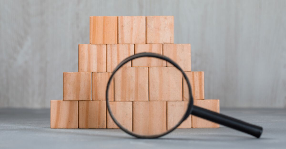 A magnifier glass pointed at a group of wooden blocks