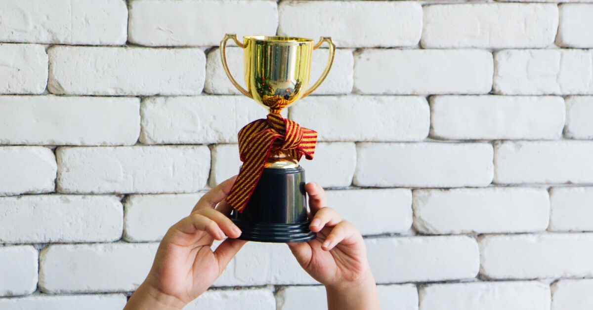 Person holding a trophy up high