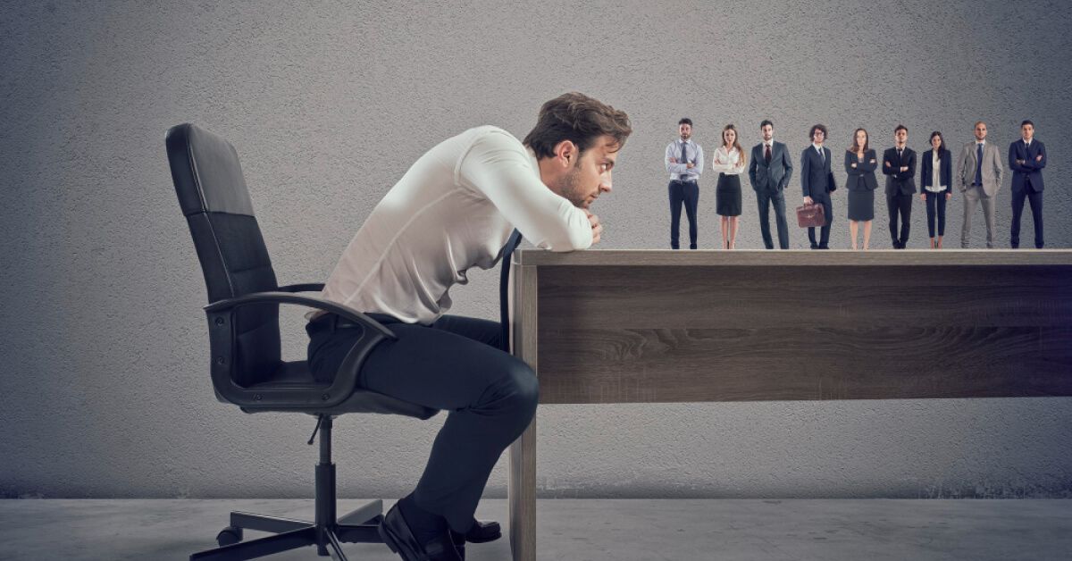 Man leaning over a table, watching a line of business people