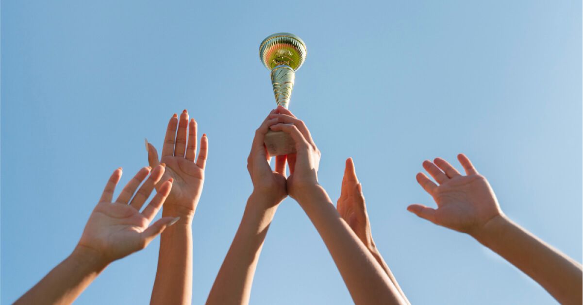 Group of people cheering with a trophy