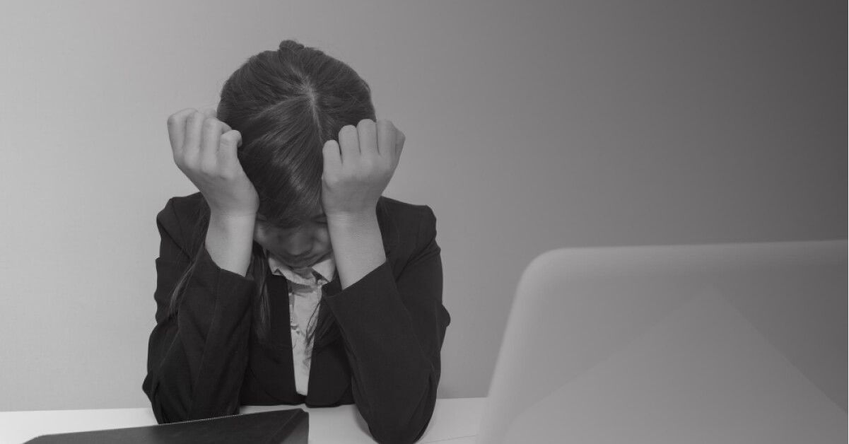 A frustrated employee in front of a laptop screen