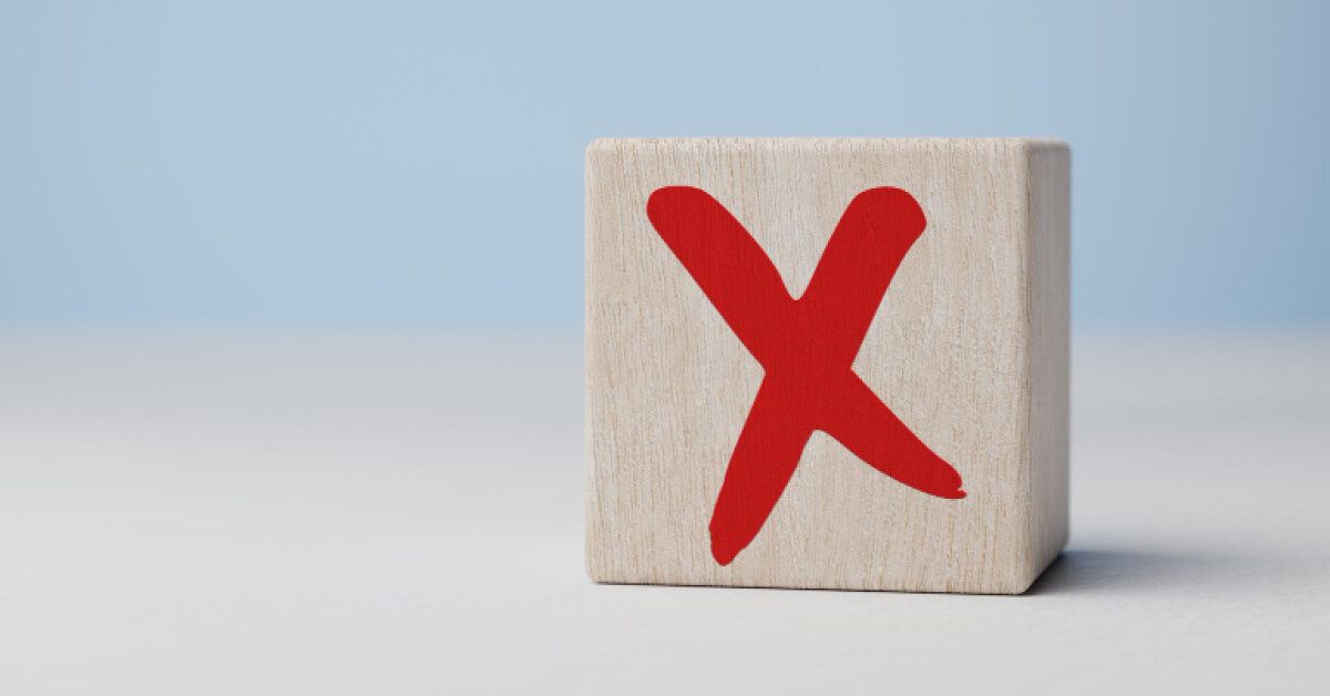 A wooden block with a red cross mark on it