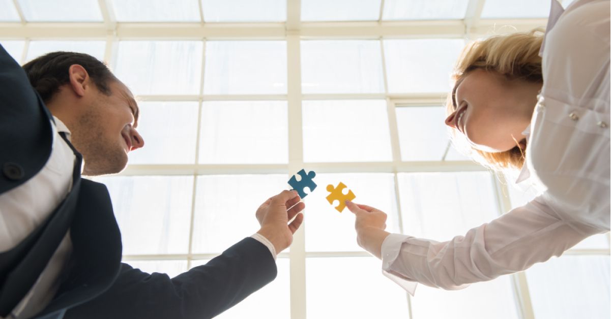 Employees joining multicolored puzzle pieces together