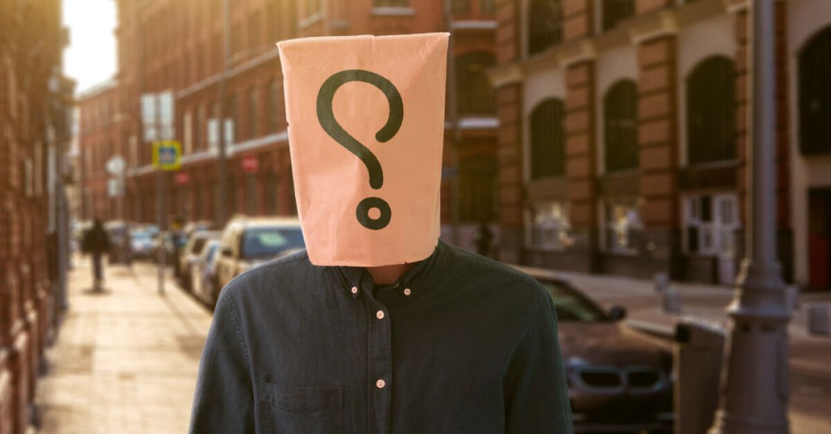 Question mark on a brown paper bag over a person's head