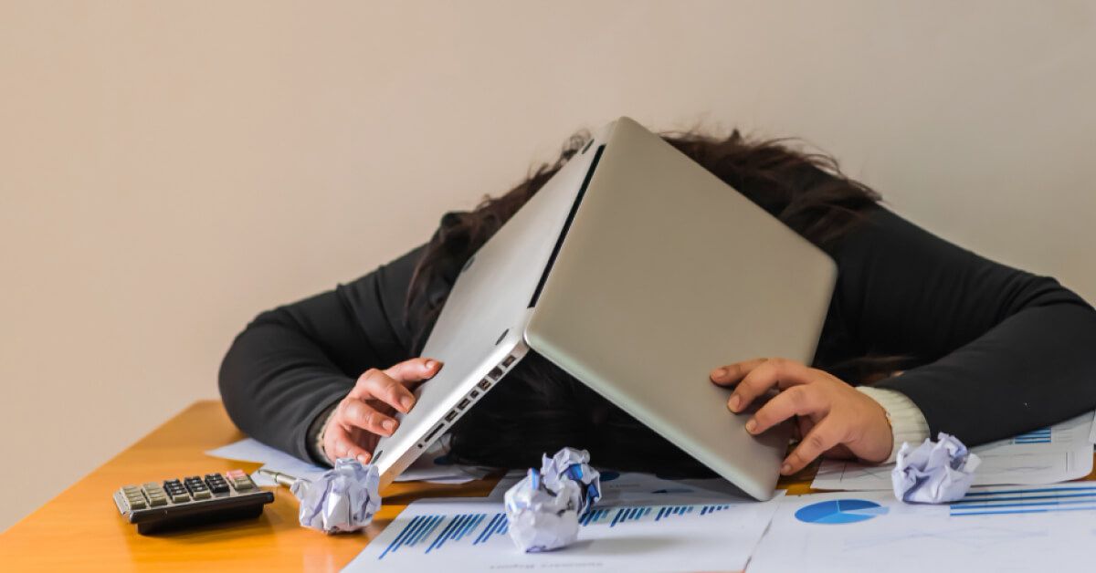 Frustrated person with an open laptop on a work desk