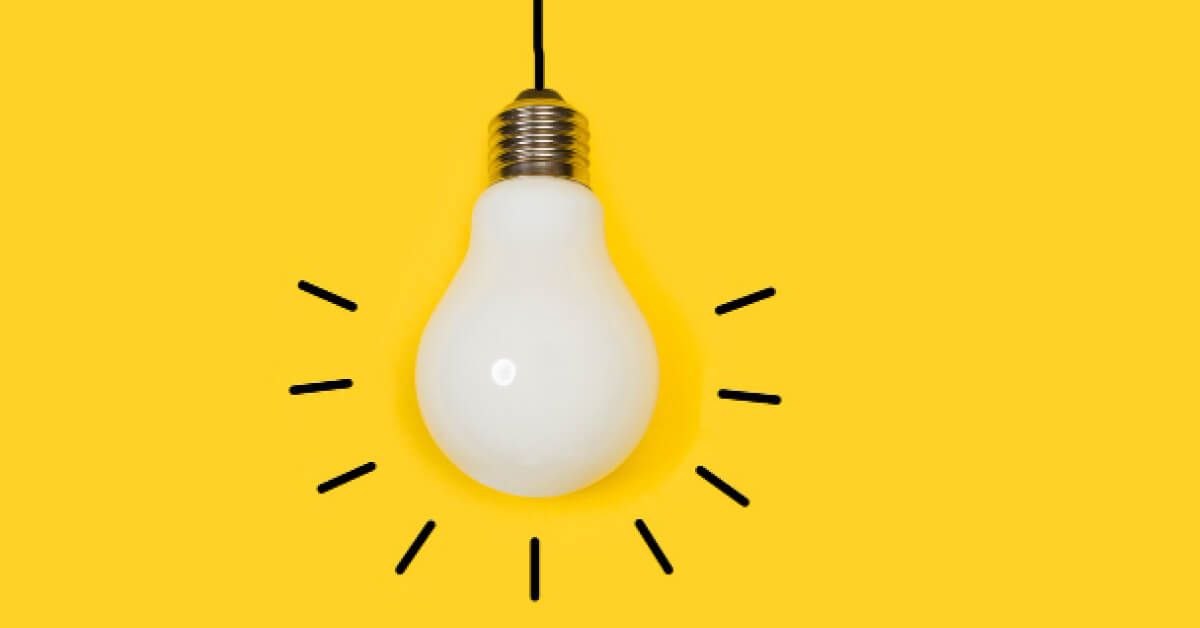 A lightbulb against yellow backdrop with lines around it