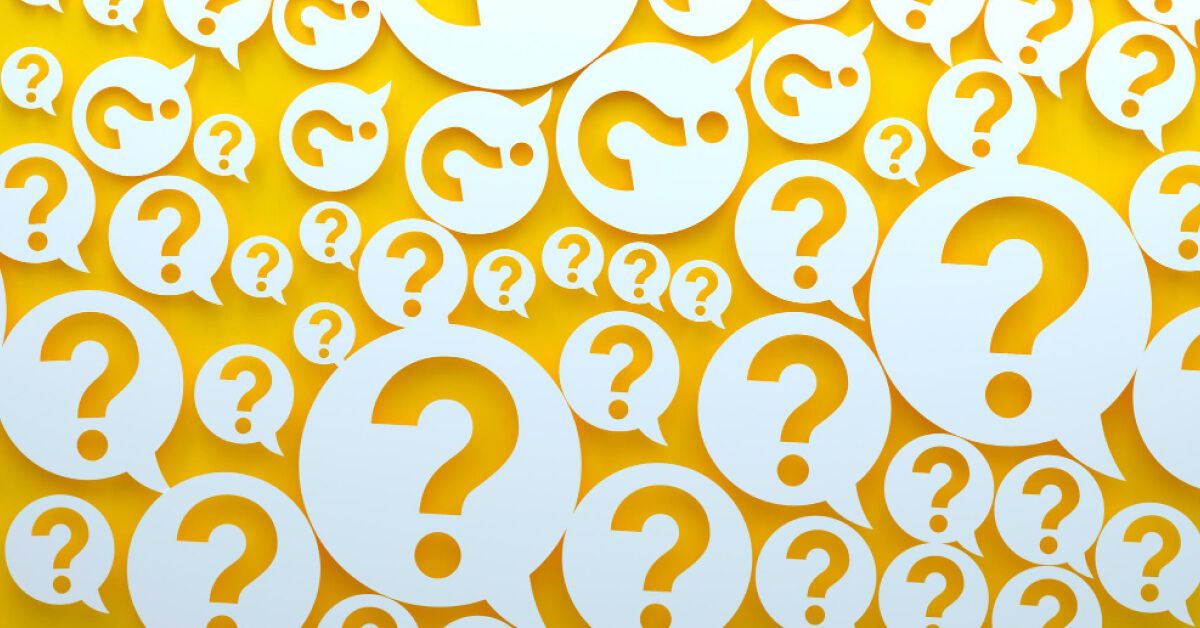 Multiple variably sized paper cutouts of message bubbles with question marks