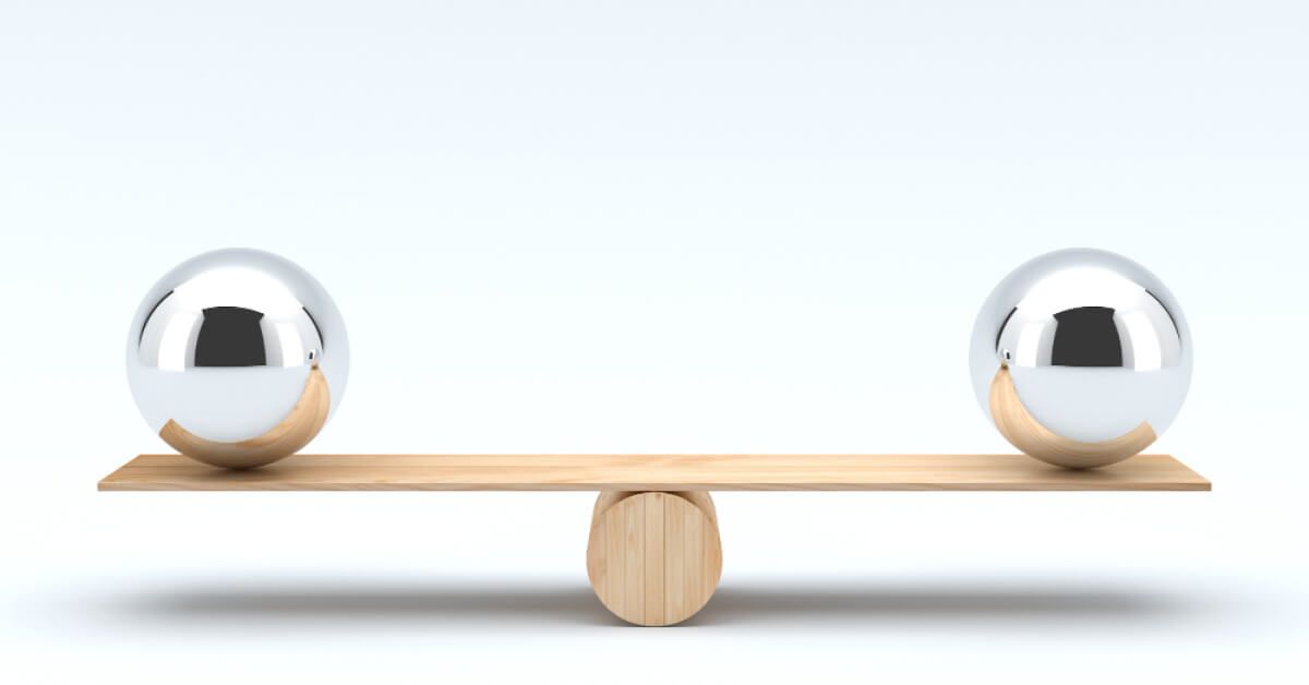 Two metal balls balanced on a wooden plank