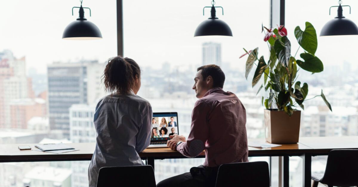 Two people in discussion in front of a laptop