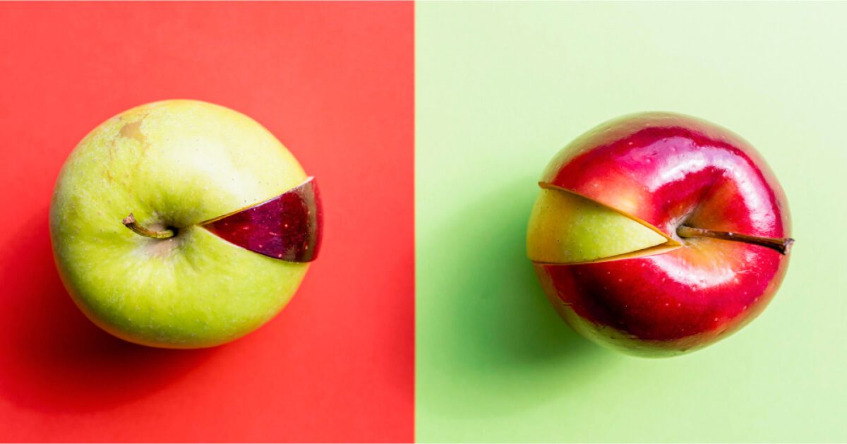 Green apple with a red slice next to a red apple with green slice