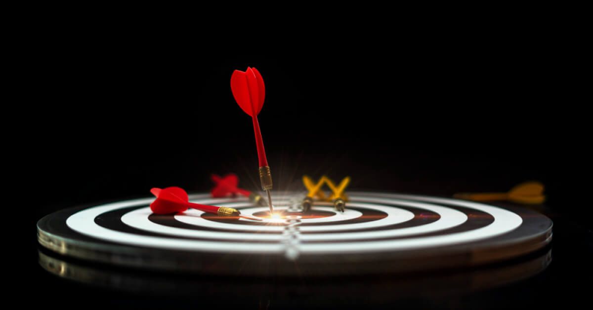 A red dart hitting the centre of a dartboard