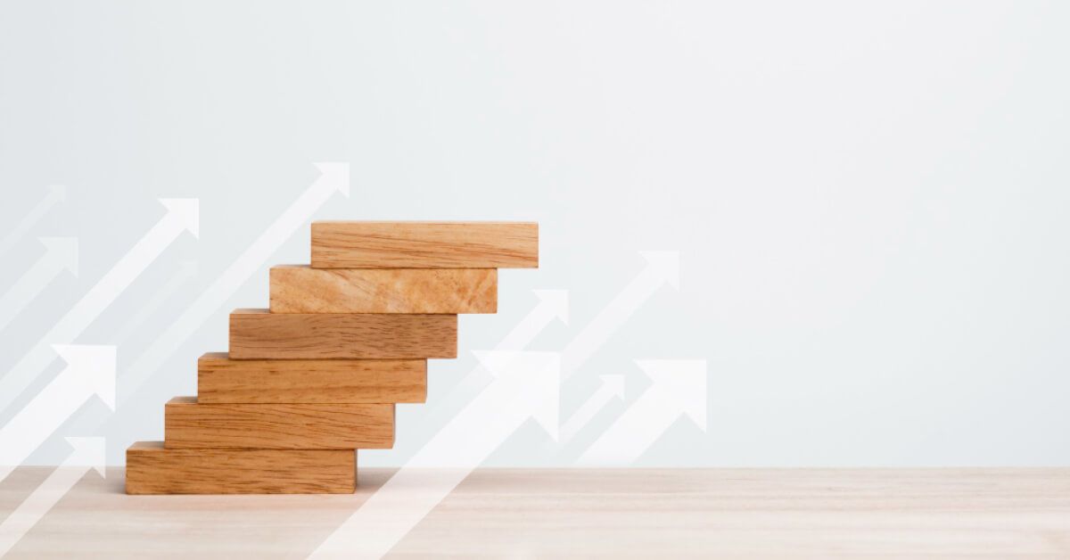 Wooden blocks arranged in a step wise manner with upward vector arrows next to it