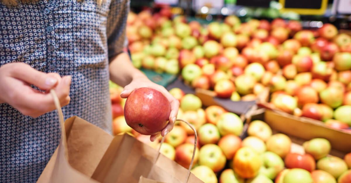 Person picking an apple in a supermarket