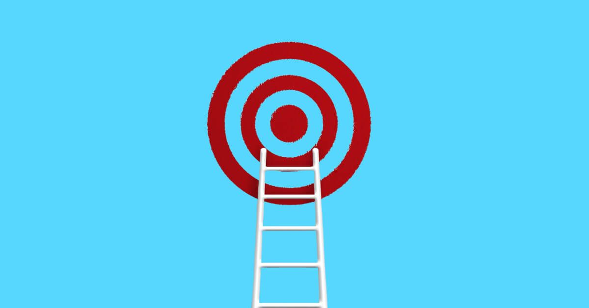 A white ladder leading up to a red and blue target board