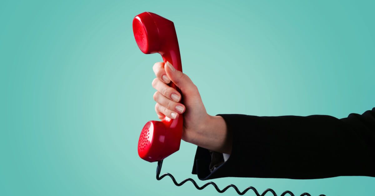 Person holding a red telephone receiver