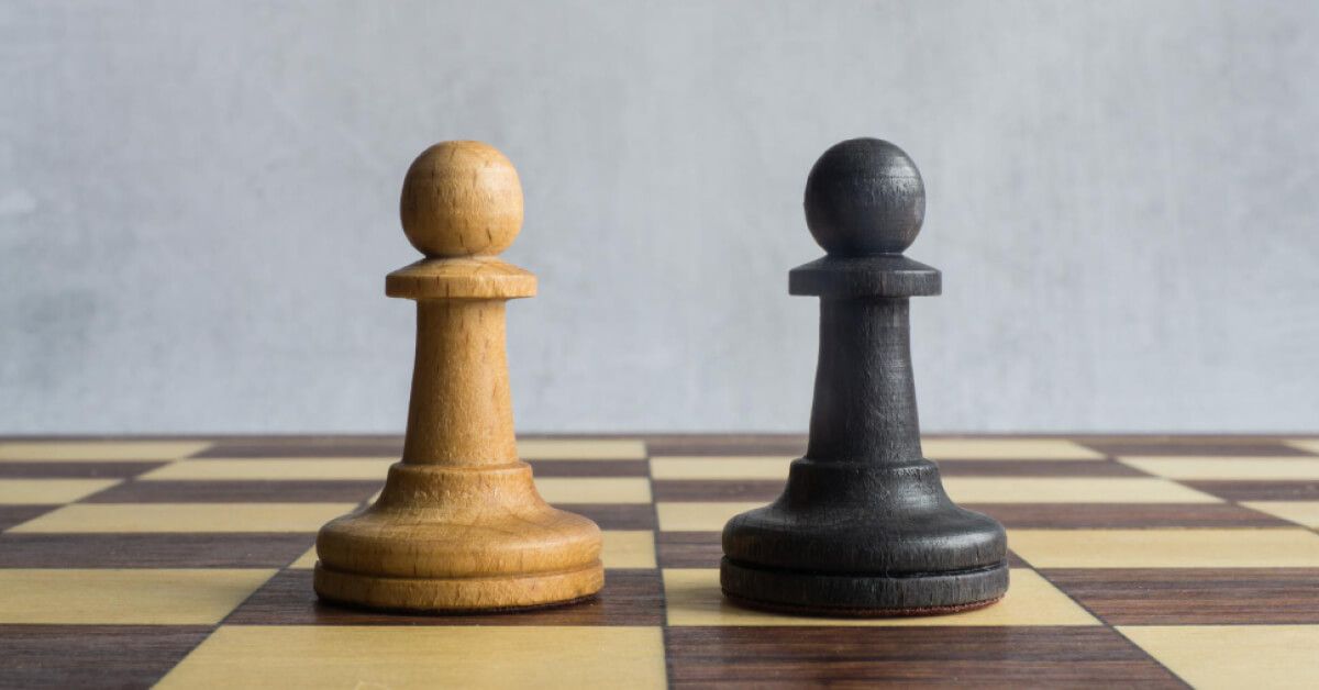 A black pawn and a white pawn next to each other on a chessboard