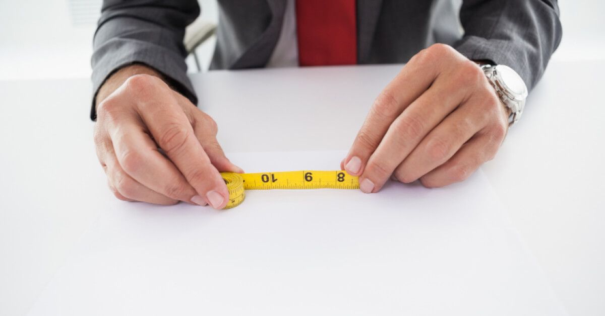 An employee holding measuring tape in his hands