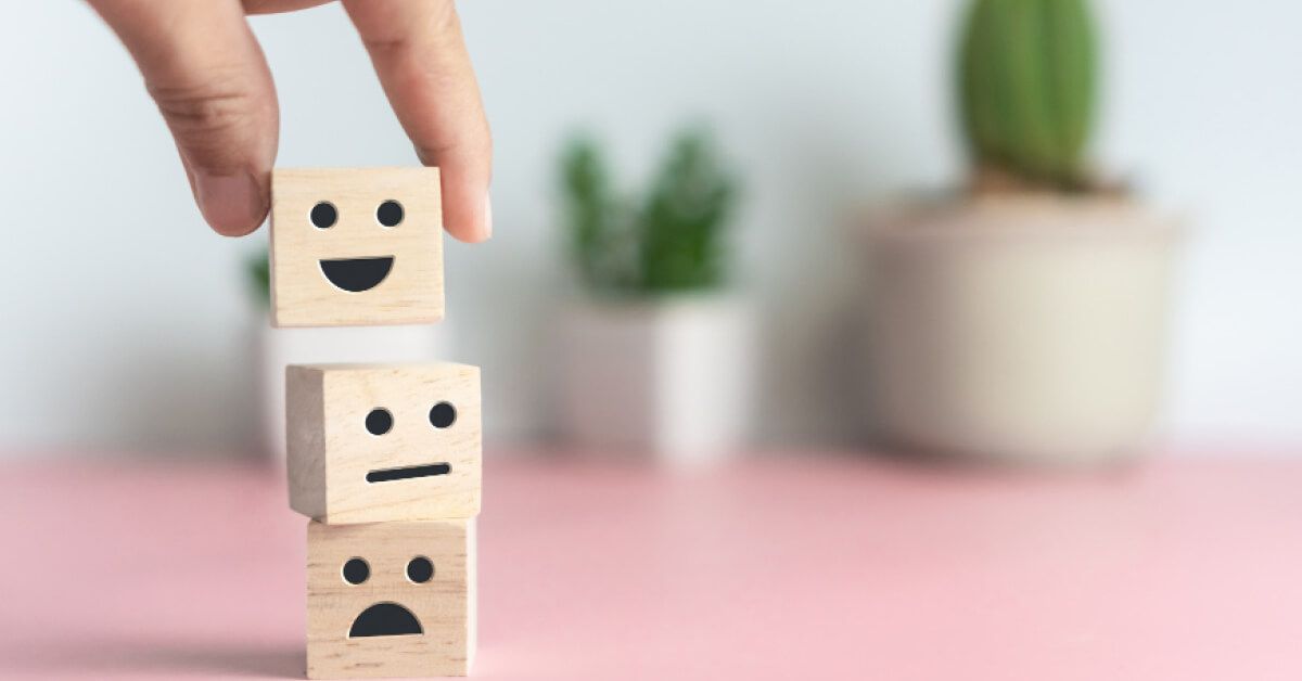 Person stacking wooden blocks with different reaction faces