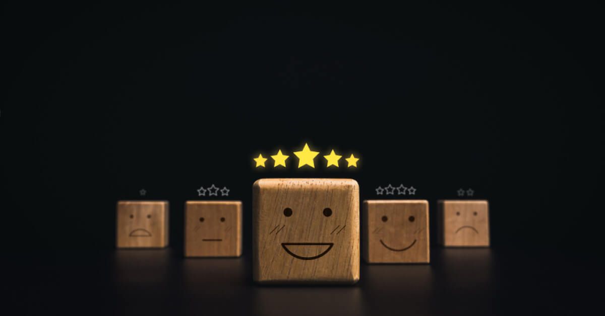 Wooden blocks with emoticon faces and rating scales above them