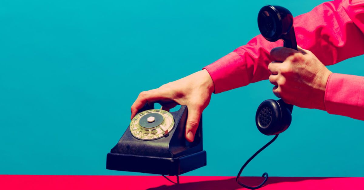 Person picking up an old telephone along with the receiver