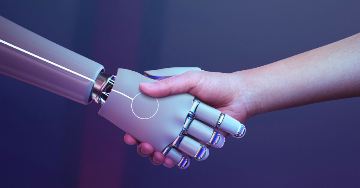 A human hand and a robotic hand participating in a handshake