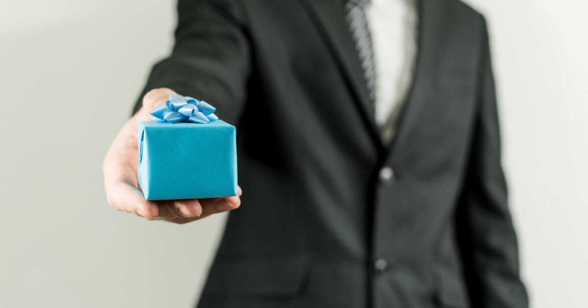 Person holding out a blue gift box