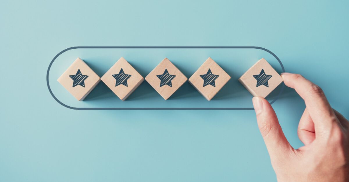 Person placing a fifth wooden block with a star on a rating scale