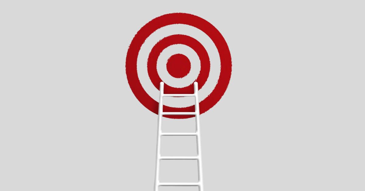 A white ladder leading up to a red and white target board