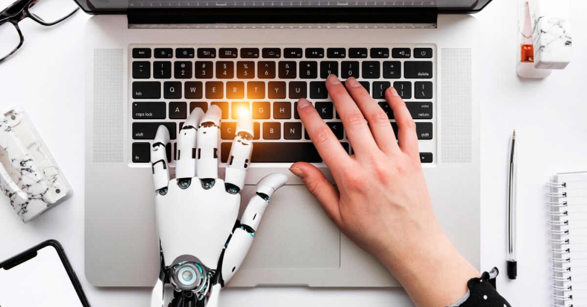 Robotic and human hands interacting with a laptop