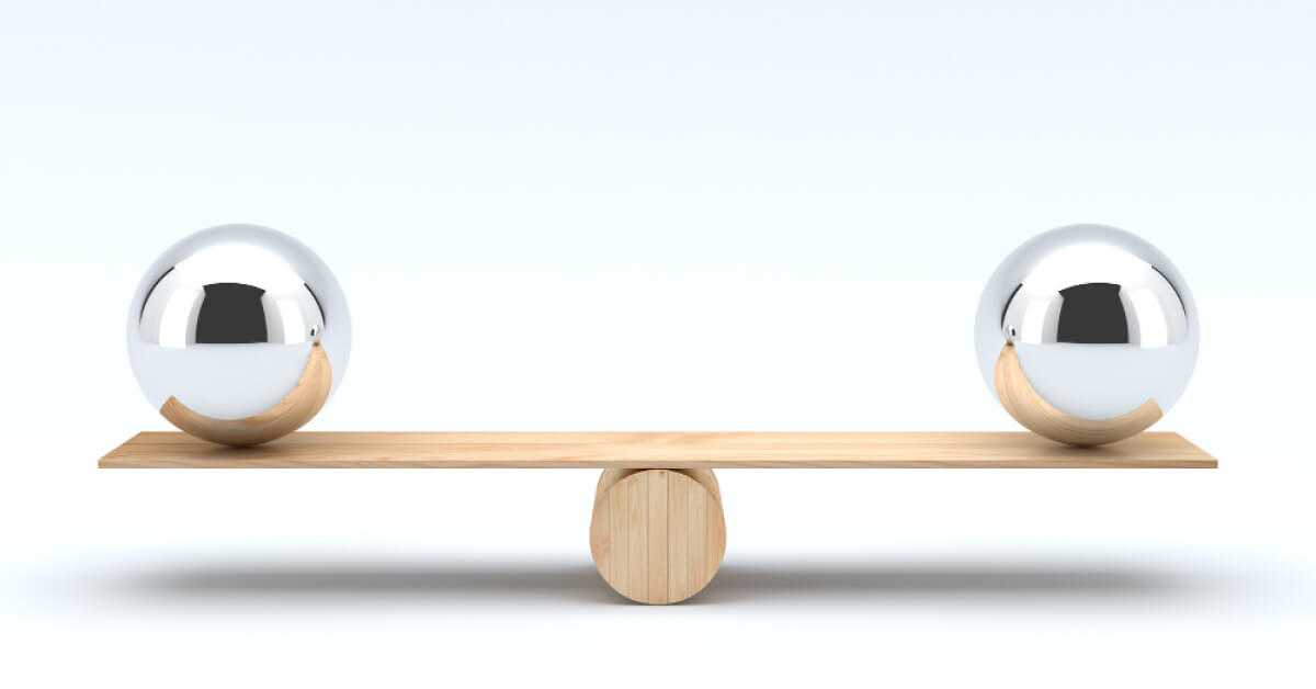 Two metal balls balanced on a wooden plank