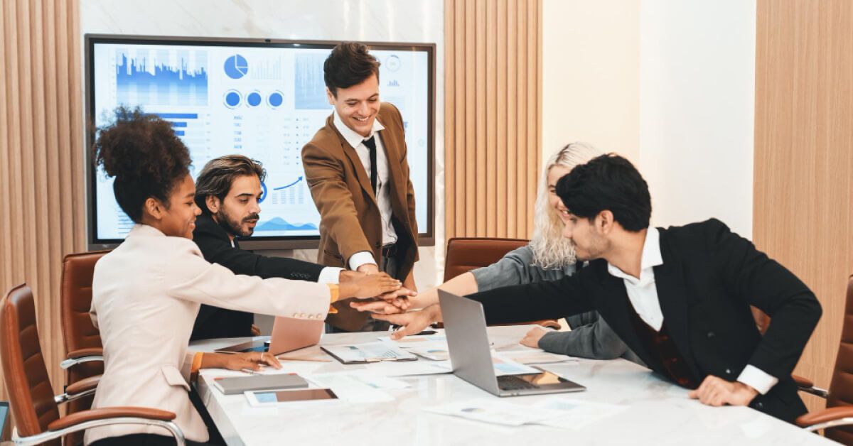 Employees in a meeting, participating in a group cheer