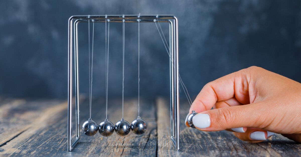 Person operating a Newton cradle