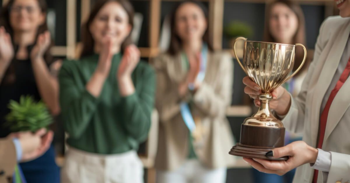 Employees are clapping their hands for anther employee who just go an award 