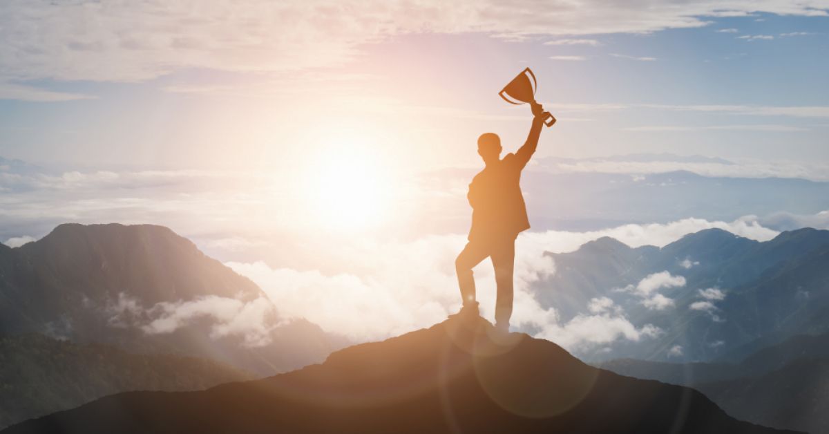 A man standing at the top of a mountain