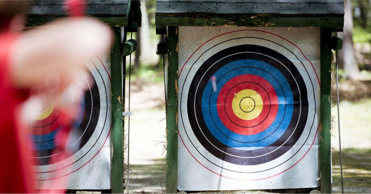 Person aiming a bow at the target