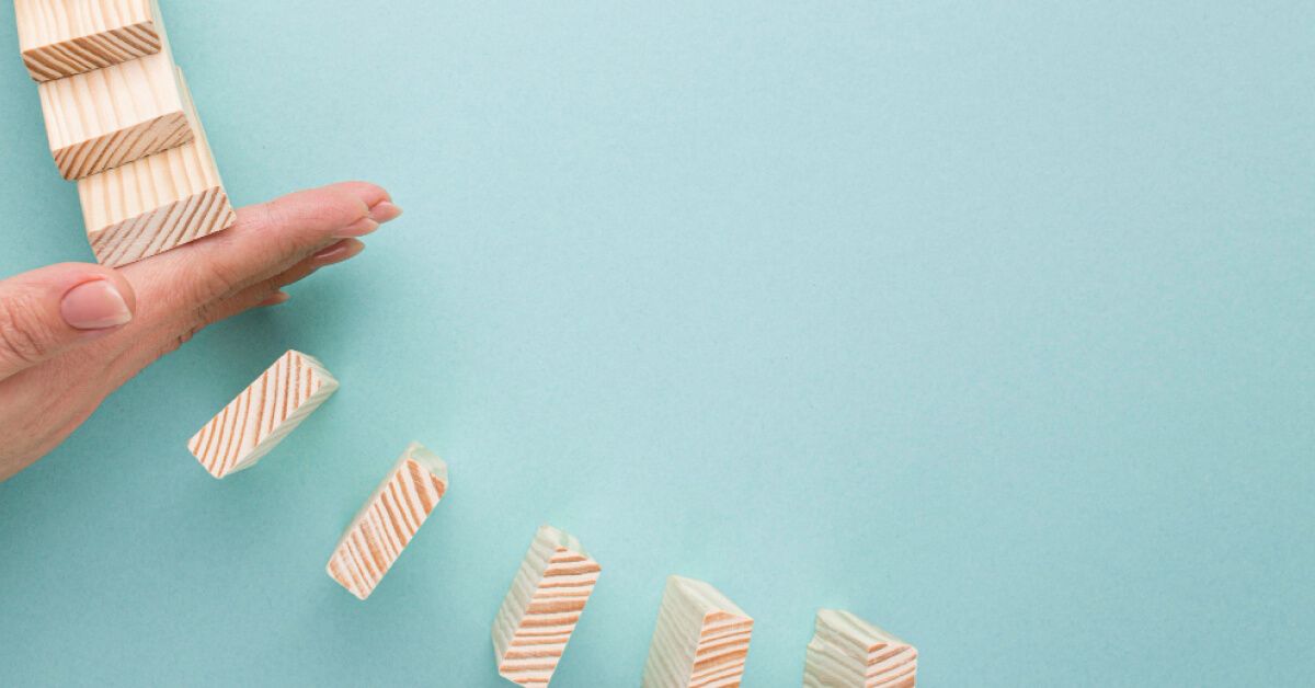 A hand prevent wooden blocks from falling