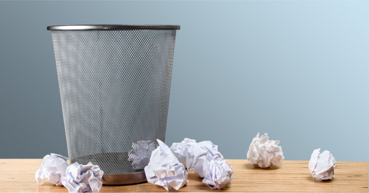 Crushed up paper balls around a dustbin