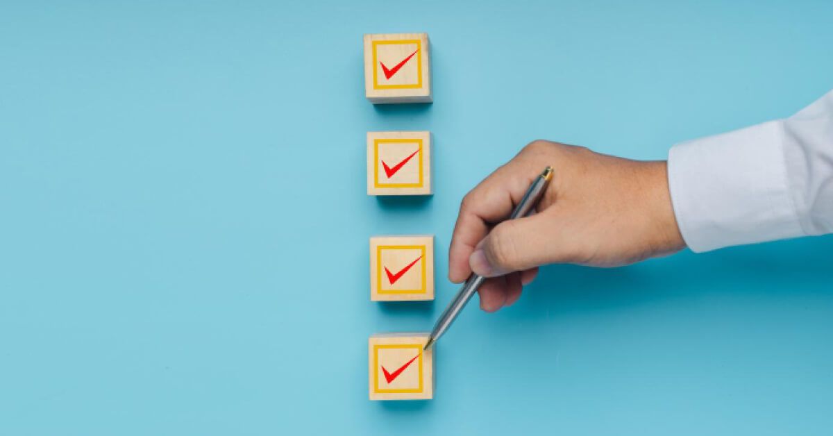 Person checking off a boxes on top of wooden blocks