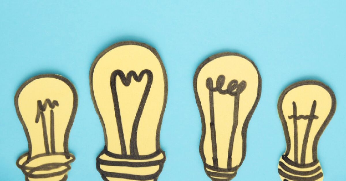 Paper cutouts of lightbulbs against a blue backdrop